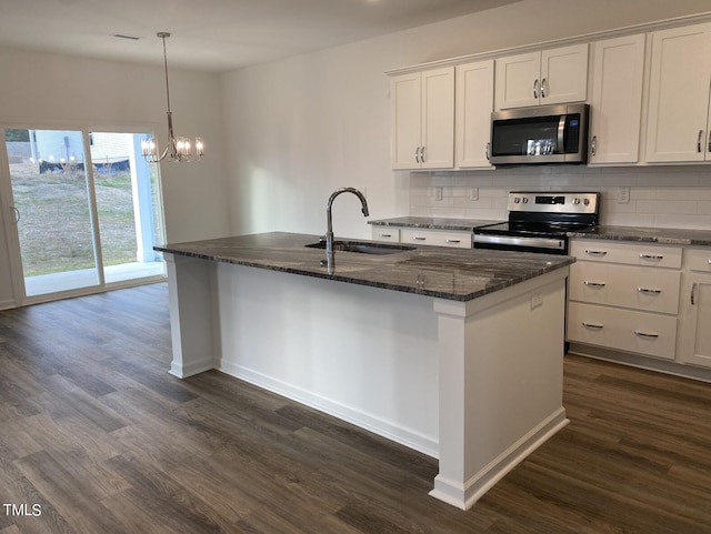 kitchen with appliances with stainless steel finishes, white cabinetry, sink, and an island with sink