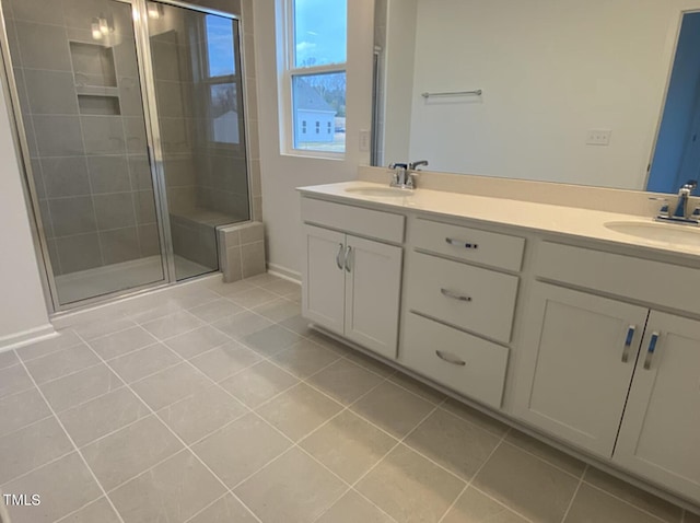 bathroom featuring tile patterned flooring, a shower with shower door, and vanity