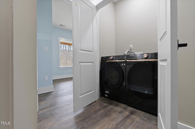 laundry area featuring dark wood-type flooring and washer and clothes dryer