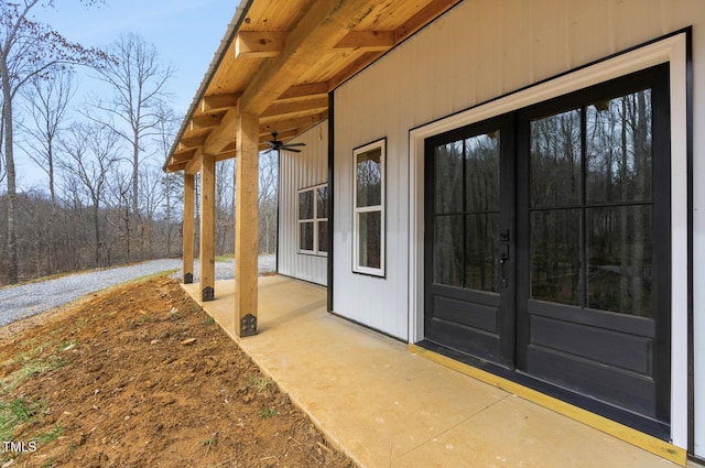 view of exterior entry with ceiling fan and a patio area