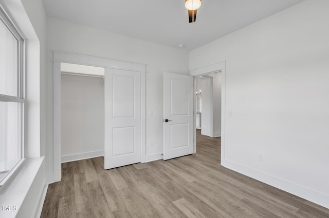 unfurnished bedroom featuring a closet, ceiling fan, and light wood-type flooring