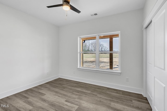 unfurnished bedroom with dark hardwood / wood-style flooring, a closet, and ceiling fan