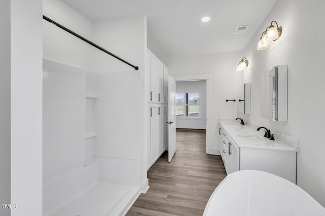 bathroom with double vanity and wood-type flooring