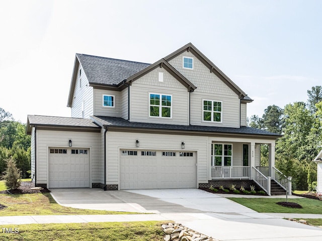 view of front of property with covered porch, an attached garage, a shingled roof, concrete driveway, and a front yard