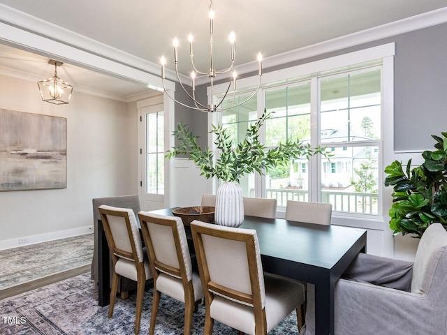 dining area with an inviting chandelier, wood finished floors, and ornamental molding
