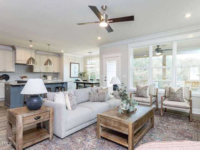 living area with a ceiling fan, recessed lighting, and crown molding