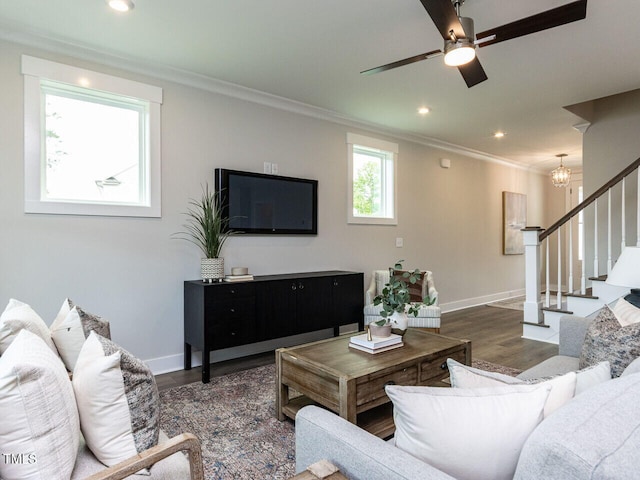 living room featuring stairway, wood finished floors, baseboards, and ornamental molding