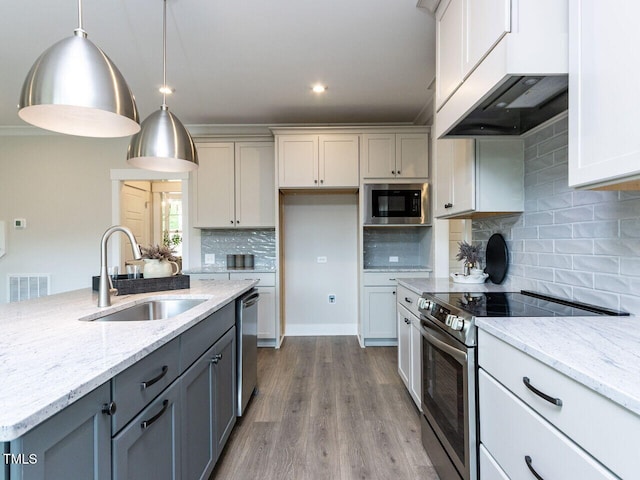 kitchen with a sink, stainless steel appliances, gray cabinets, visible vents, and decorative backsplash