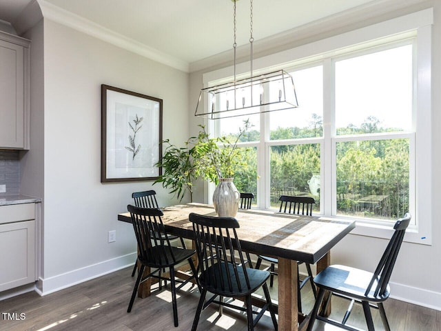 dining area with crown molding, plenty of natural light, baseboards, and a notable chandelier