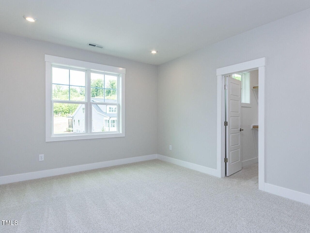 carpeted empty room featuring visible vents, baseboards, and recessed lighting