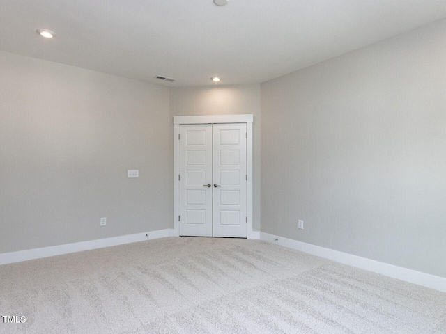 empty room featuring baseboards, visible vents, recessed lighting, and carpet