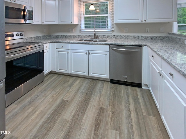 kitchen featuring white cabinetry, appliances with stainless steel finishes, plenty of natural light, and sink