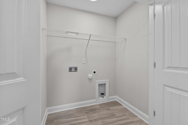 clothes washing area featuring hookup for a gas dryer, hookup for a washing machine, light hardwood / wood-style floors, and hookup for an electric dryer