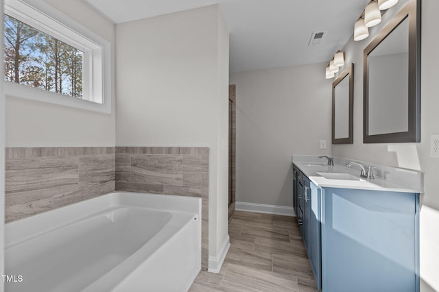 345 Sutherland Dr, Franklinton, NC 27525 - bathroom with a garden tub, double vanity, baseboards, and a shower