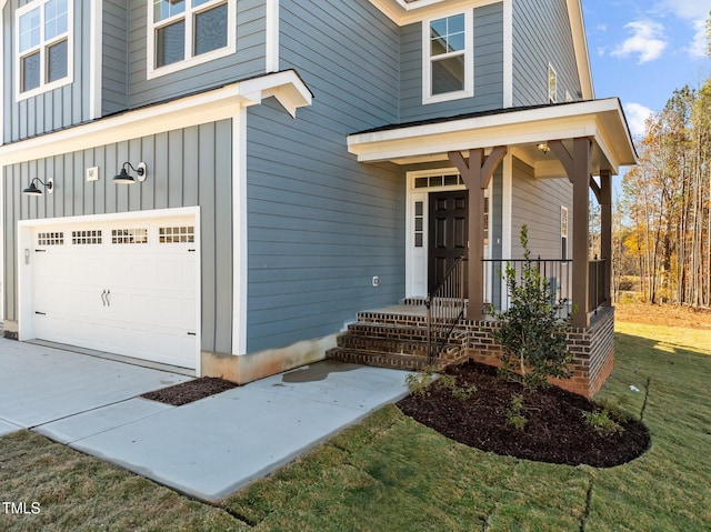 345 Sutherland Dr, Franklinton, NC 27525 - doorway to property featuring an attached garage, board and batten siding, concrete driveway, a porch, and a yard