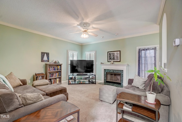 carpeted living room with ceiling fan, a high end fireplace, a textured ceiling, and crown molding