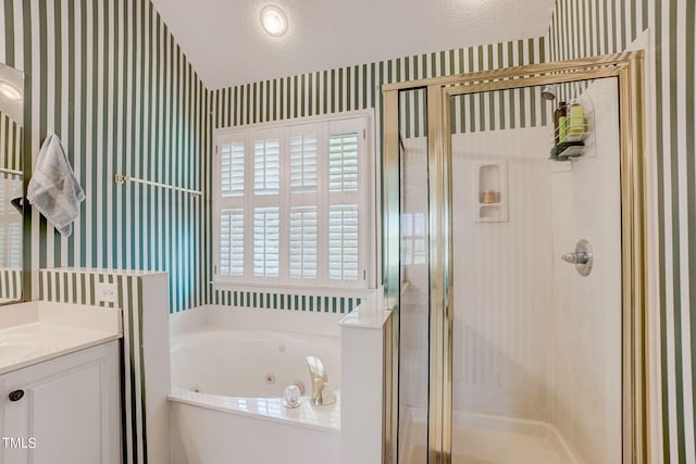 bathroom featuring plus walk in shower, vanity, and a textured ceiling