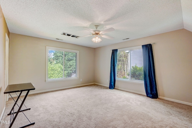 spare room with ceiling fan, a textured ceiling, and a healthy amount of sunlight