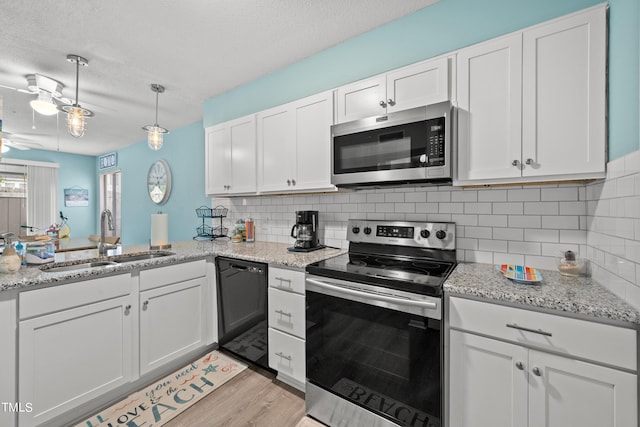 kitchen featuring ceiling fan, white cabinets, sink, stainless steel appliances, and light hardwood / wood-style floors