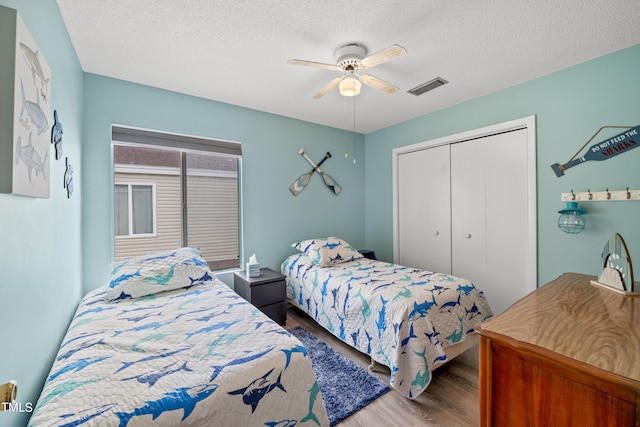 bedroom with a closet, hardwood / wood-style floors, a textured ceiling, and ceiling fan