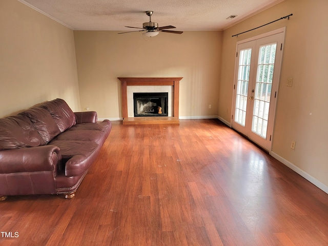 living room featuring french doors, wood-type flooring, ceiling fan, and a textured ceiling