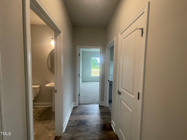 hall with dark colored carpet