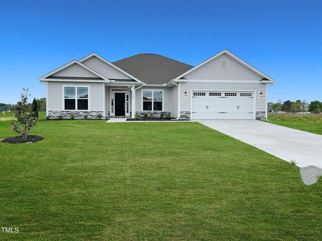 craftsman inspired home featuring a garage and a front lawn