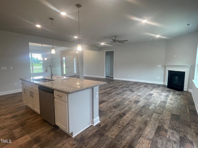 kitchen featuring pendant lighting, sink, white cabinets, a center island with sink, and stainless steel dishwasher