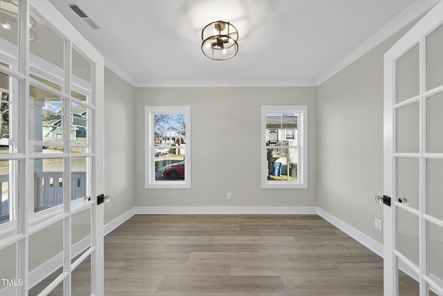 unfurnished room with light hardwood / wood-style flooring, ornamental molding, and french doors