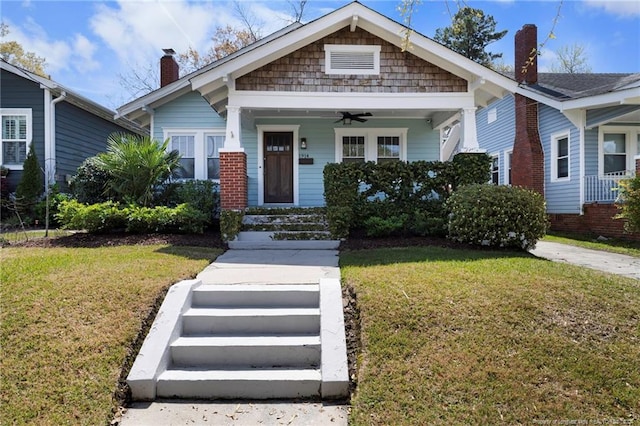 bungalow-style home with ceiling fan and a front yard