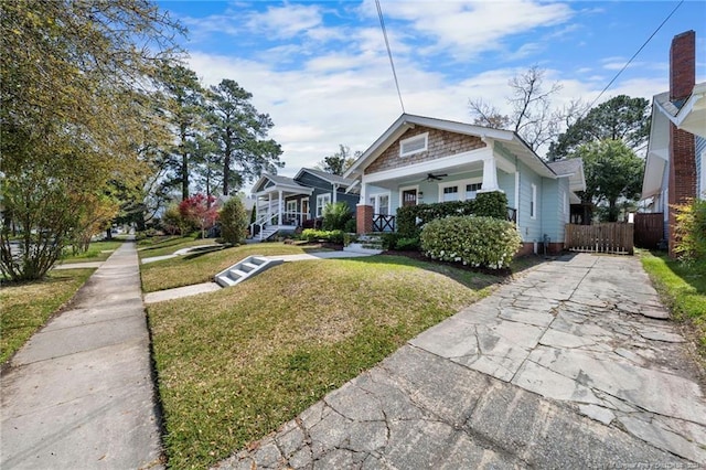 bungalow with covered porch and a front yard