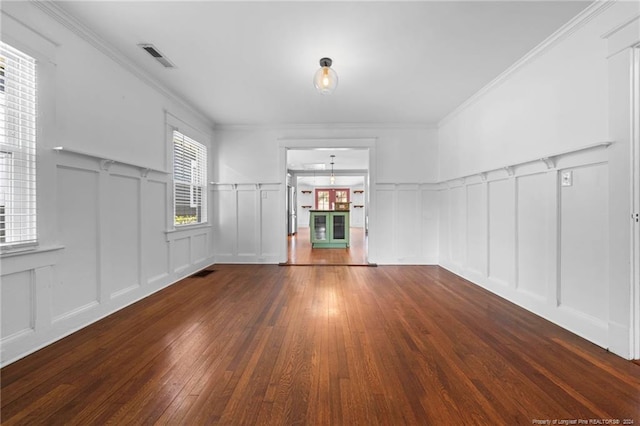 empty room with crown molding and dark wood-type flooring