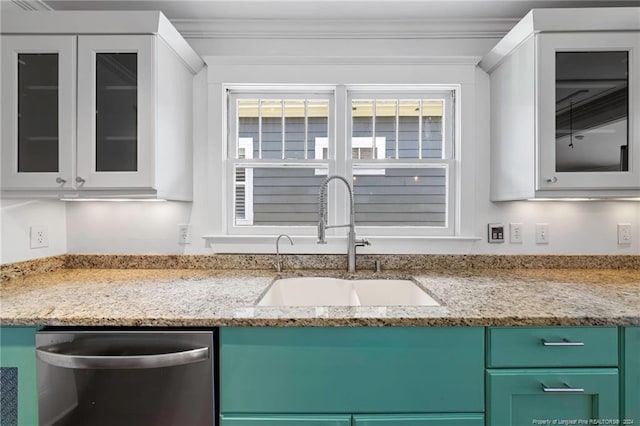 kitchen featuring a wealth of natural light, stainless steel dishwasher, white cabinetry, and sink