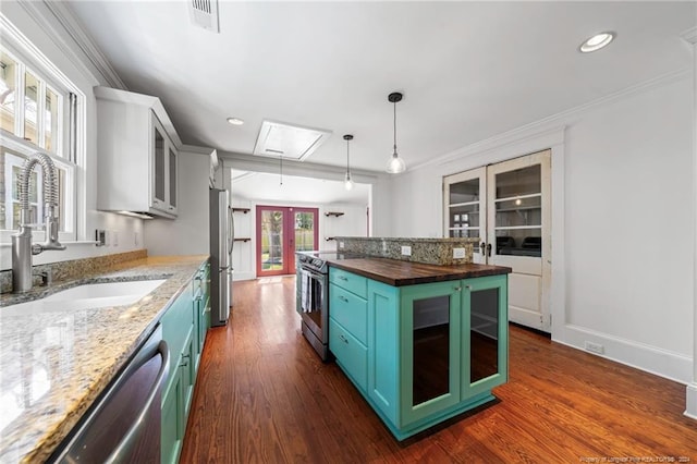 kitchen featuring a center island, french doors, sink, hanging light fixtures, and dark hardwood / wood-style flooring