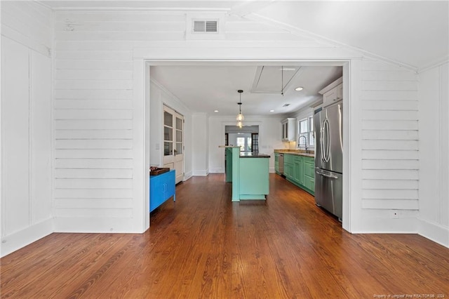 kitchen with dark hardwood / wood-style flooring, pendant lighting, stainless steel appliances, and green cabinetry