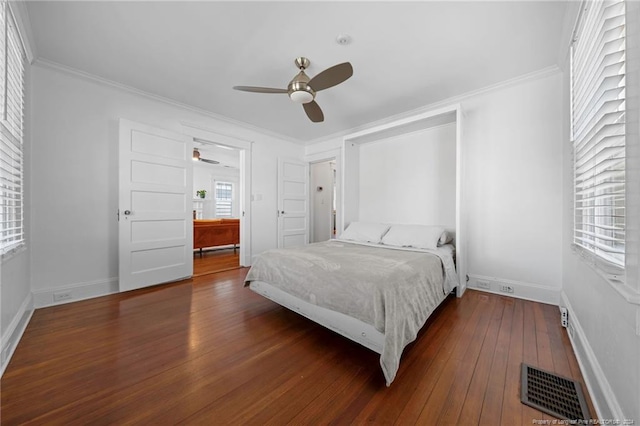 bedroom with crown molding, dark hardwood / wood-style floors, and ceiling fan