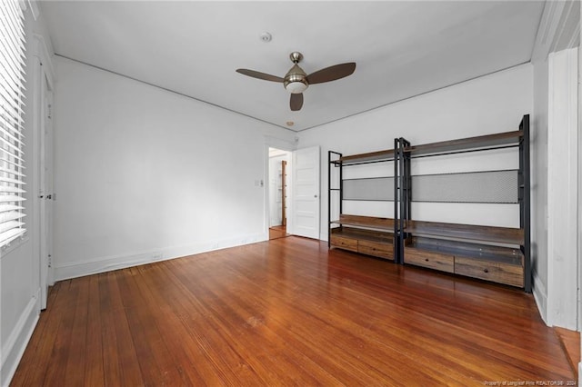 unfurnished room featuring ceiling fan, dark wood-type flooring, and a barn door