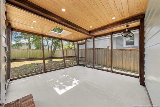 unfurnished sunroom with a skylight, beamed ceiling, and wood ceiling