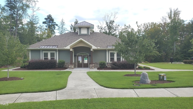 view of front of house featuring a front yard and roof with shingles