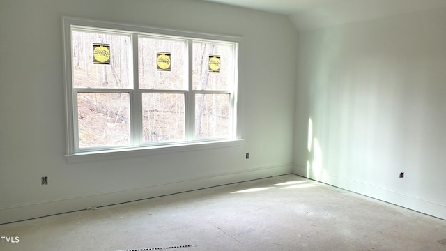 empty room featuring plenty of natural light and lofted ceiling