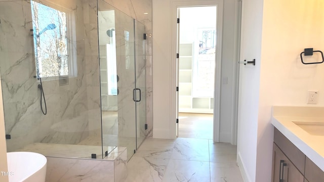 full bathroom with a marble finish shower, baseboards, marble finish floor, a freestanding bath, and vanity