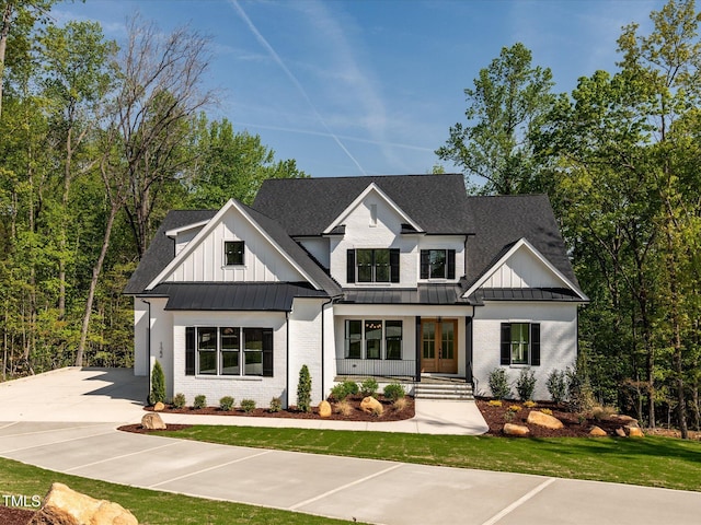 122 W Beech Slope Ct, Chapel Hill, NC 27517 - view of front of house featuring a standing seam roof, metal roof, driveway, brick siding, and a shingled roof