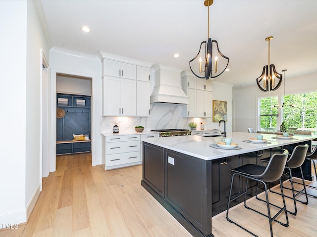 122 W Beech Slope Ct, Chapel Hill, NC 27517 - kitchen featuring decorative backsplash, a sink, a chandelier, custom range hood, and white cabinetry