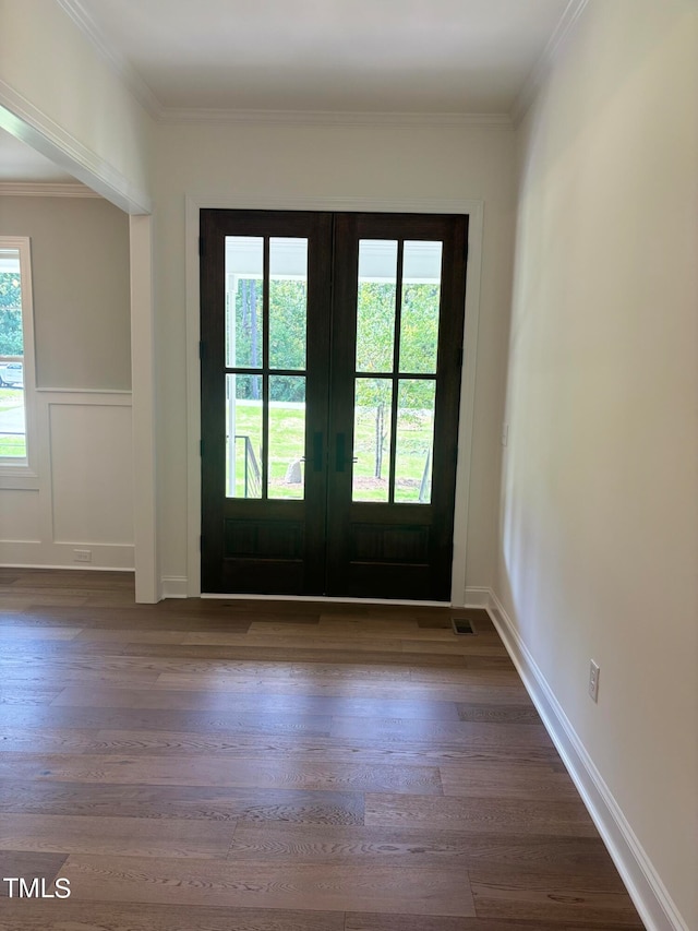 doorway with dark hardwood / wood-style floors, plenty of natural light, french doors, and crown molding