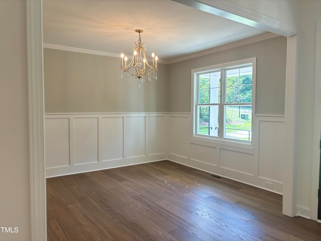 unfurnished room with ornamental molding, dark wood-type flooring, and a chandelier