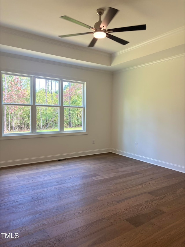 empty room with ceiling fan, dark hardwood / wood-style floors, and ornamental molding