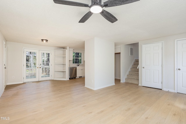 unfurnished living room featuring french doors, a textured ceiling, light wood-type flooring, and ceiling fan