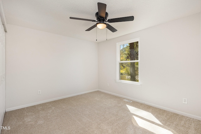 empty room featuring carpet floors, a textured ceiling, and ceiling fan