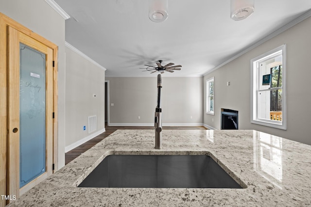 kitchen with sink, ceiling fan, dark wood-type flooring, and light stone counters