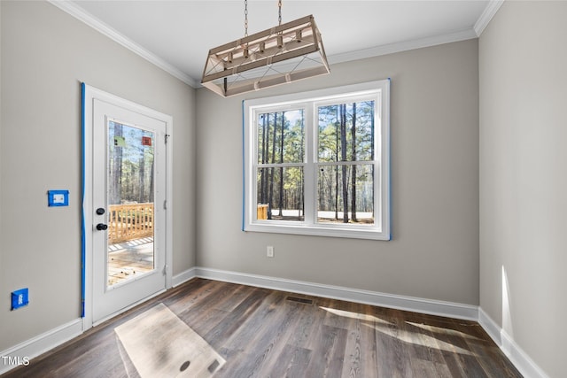 unfurnished room with dark wood-type flooring, a notable chandelier, and ornamental molding